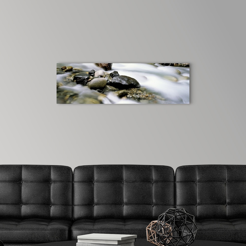 A modern room featuring Up-close panoramic photograph of rocky stream with rising mist.