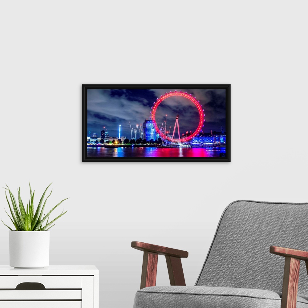 A modern room featuring View of the brightly colored ferris wheel at night in London, England.