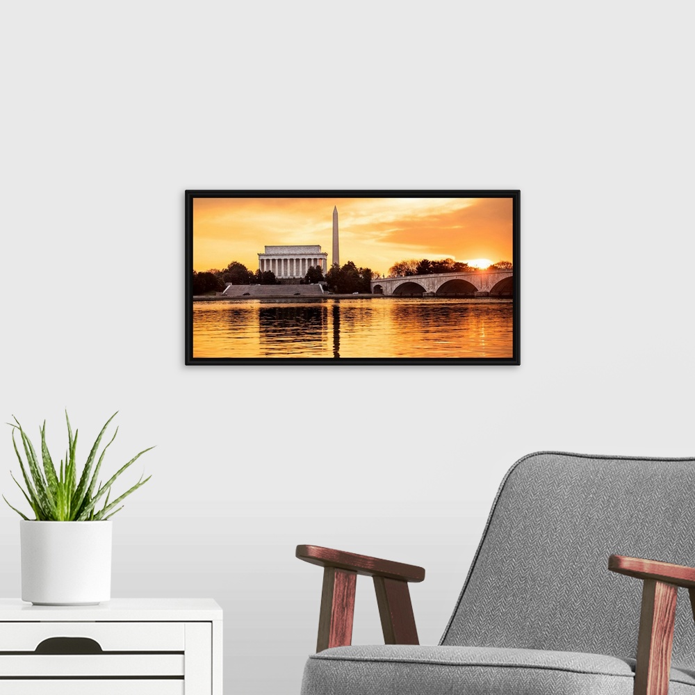A modern room featuring The Lincoln Memorial and Washington Monument seen from the Potomac River with orange clouds at dusk.