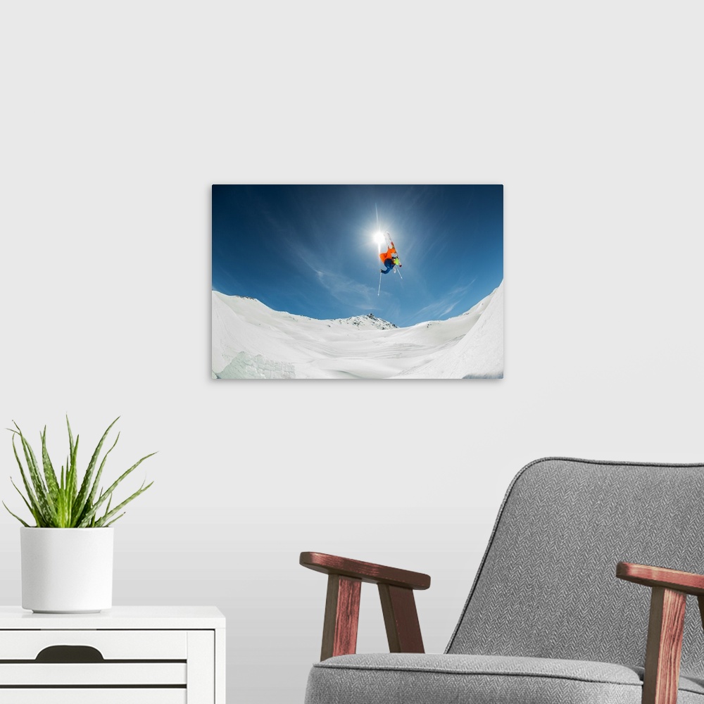 A modern room featuring A skier flying through the air over a snowy landscape, Italy.