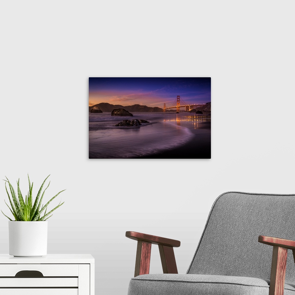A modern room featuring Lights on the Golden Gate Bridge in San Francisco seen from the beach at twilight.