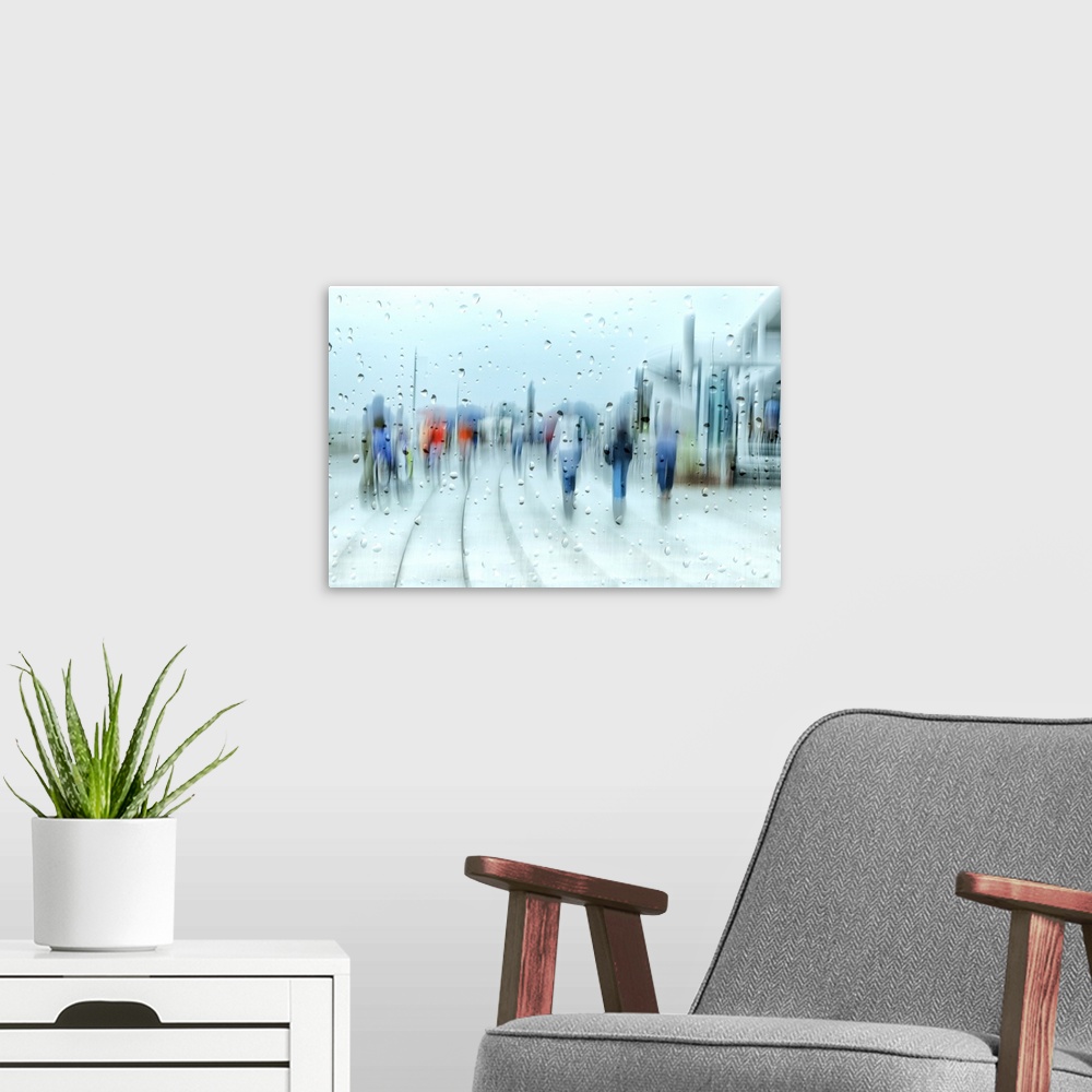 A modern room featuring People walking in the street on a rainy day, seen behind blurry glass with raindrops.