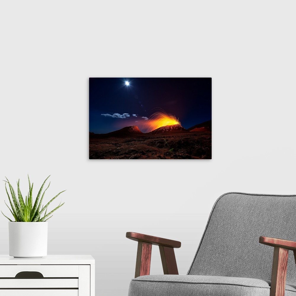 A modern room featuring A volcano erupting at night in the moonlight on the island of Reunion, off the coast of Madagascar.