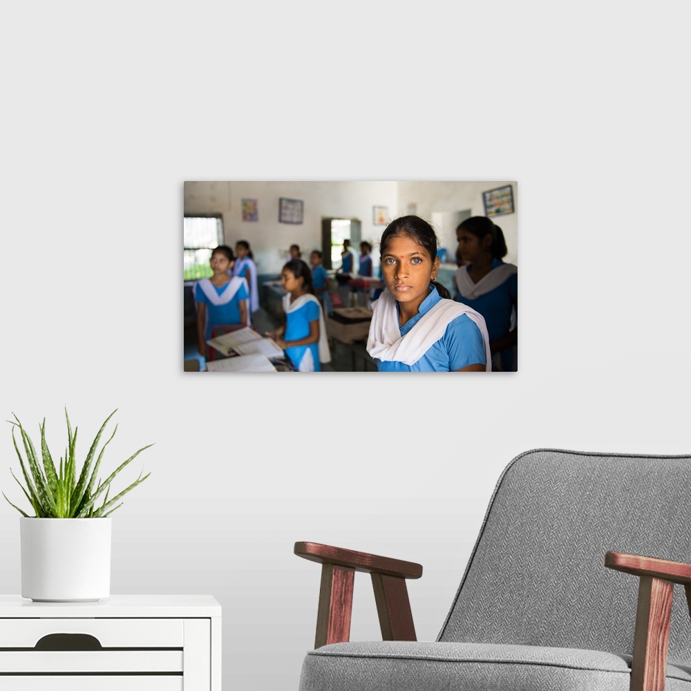 A modern room featuring A young Indian woman with deep blue eyes in a classroom.