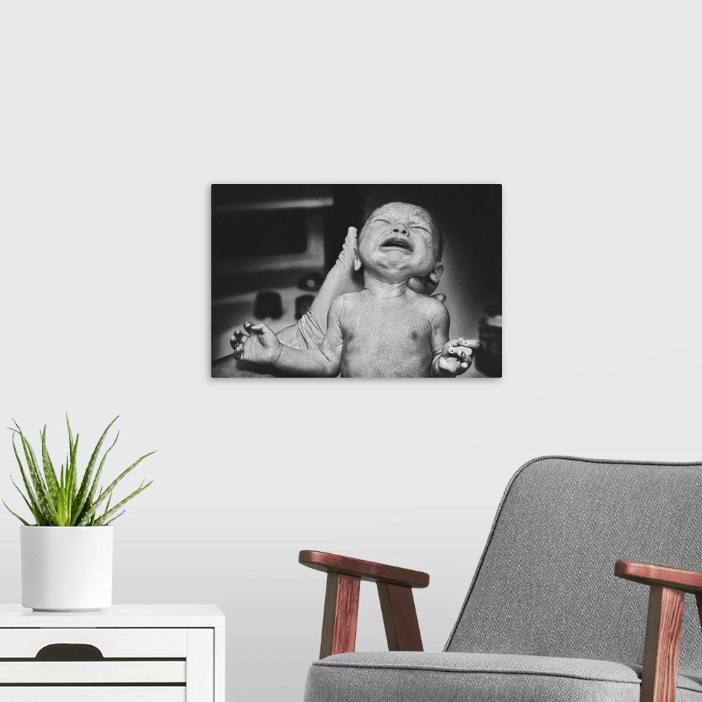 A modern room featuring A newbown baby cries as they take their first breath.
