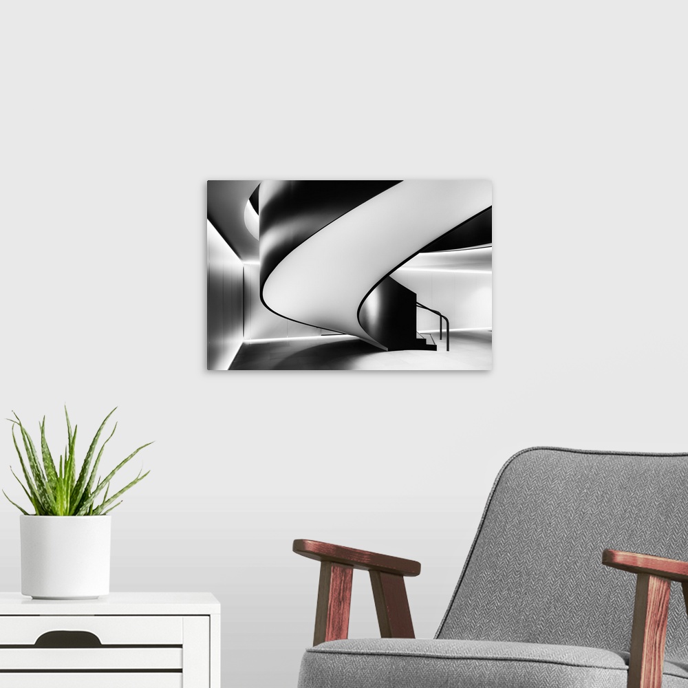 A modern room featuring High contrast black and white image of the underside of a modern spiral staircase.