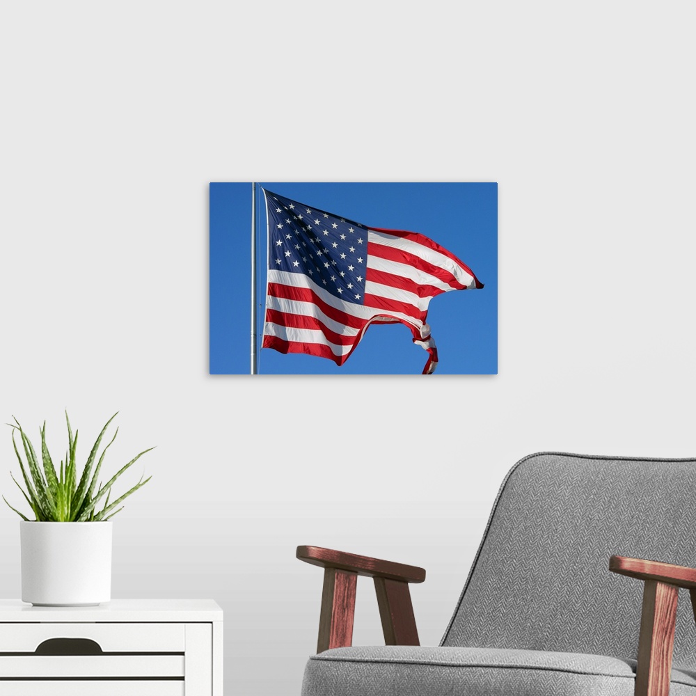 A modern room featuring A furled American flag waving during a blue sky day
