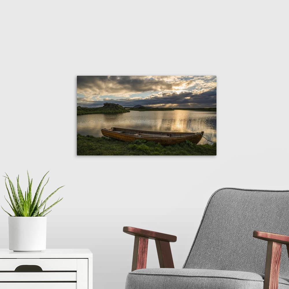 A modern room featuring A boat lies in a placid Lake Myvatn, North Iceland at sunset, Iceland