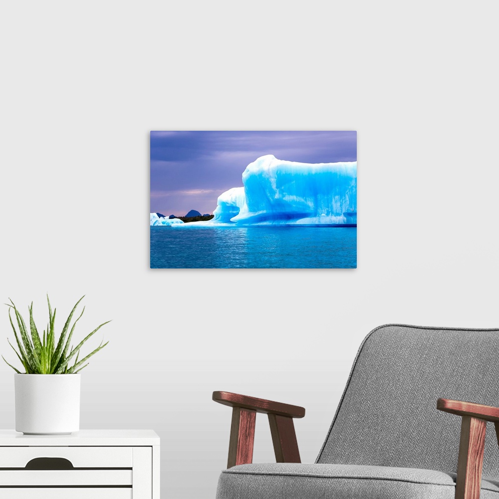 A modern room featuring A vibrant blue iceberg floats in Bear Glacier Lagoon in Kenai Fjords National Park on an overcast...