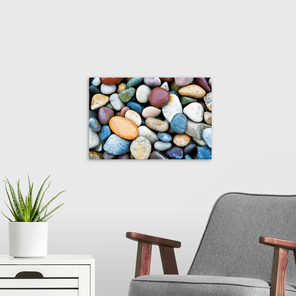 A modern room featuring A horizontal photograph of smooth river stones piled on a beach. This calming photograph would ma...