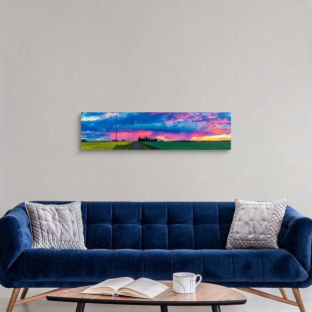A modern room featuring Dramatic colourful sky at sunset over green farmland and a country road; Alberta, Canada