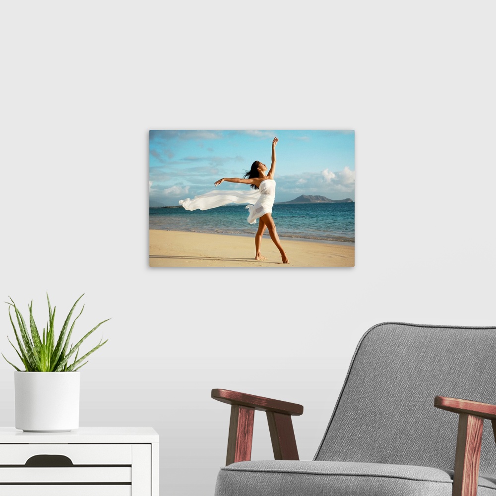 A modern room featuring Big canvas of a woman with a white sheets wrapped around her poses on a Hawaiian beach.