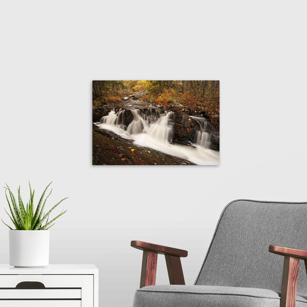 A modern room featuring Waterfall on an autumn coloured landscape near Grand Lake; Nova Scotia, Canada