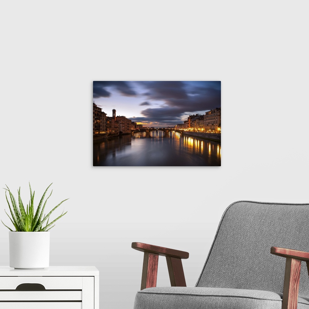 A modern room featuring Arno, city with lights reflecting from the bridge