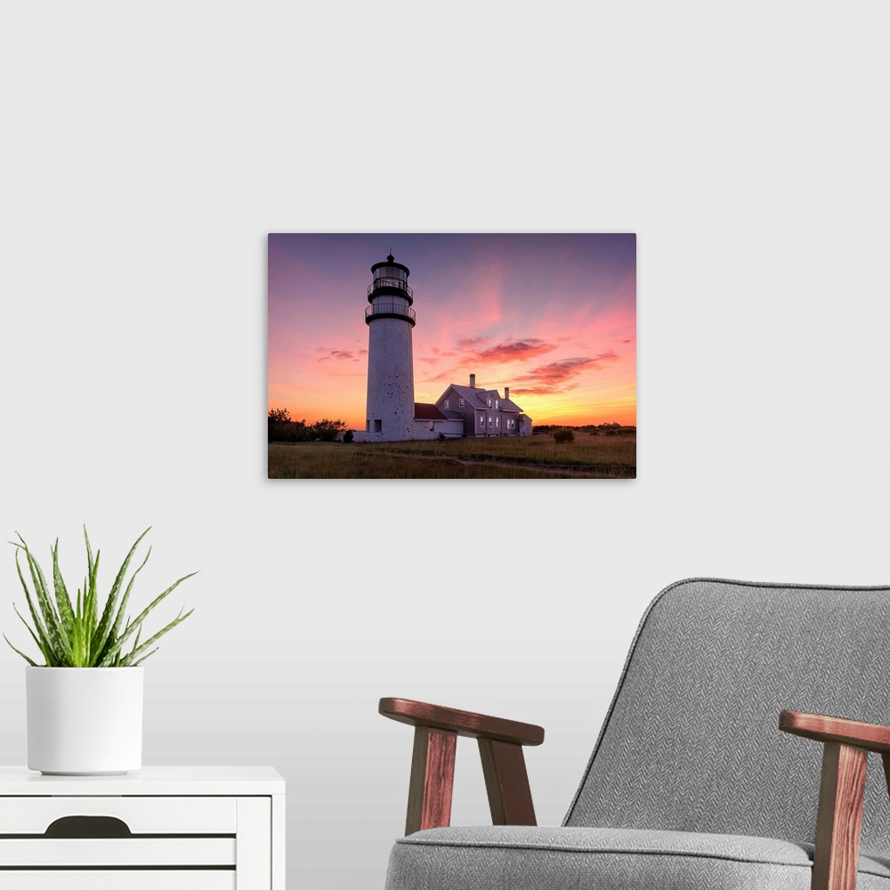 A modern room featuring Photograph of the Cape Cod Highland Lighthouse at sunset.