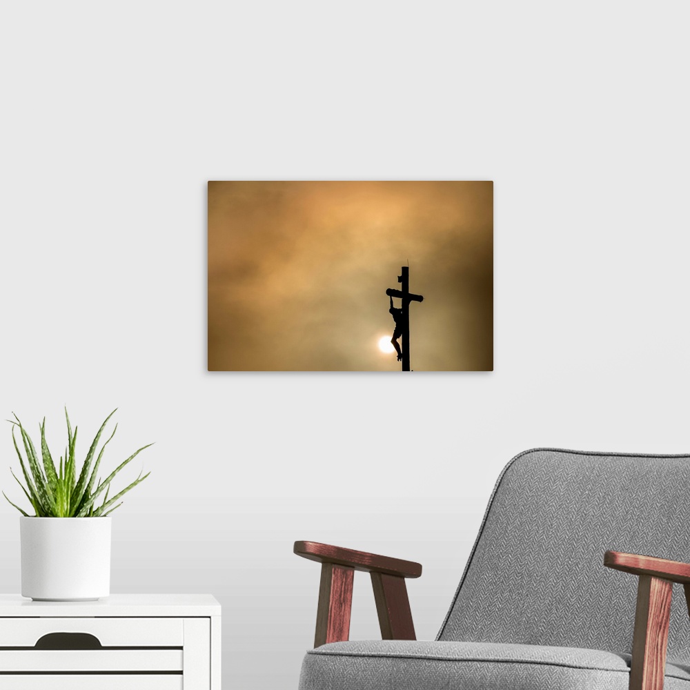 A modern room featuring Silhouette of Christ on the cross at sunset.