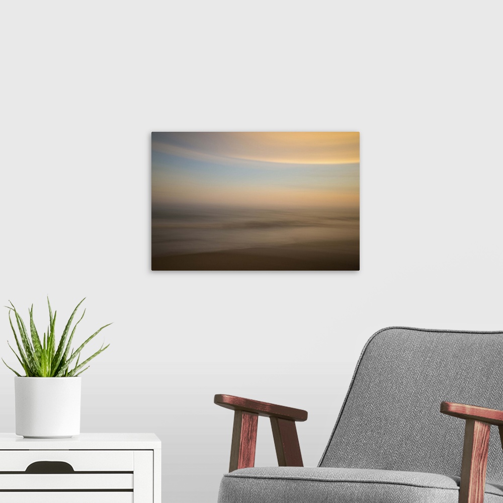A modern room featuring An artistic abstract photograph of a light blue and orange motion blurred cloudscape.