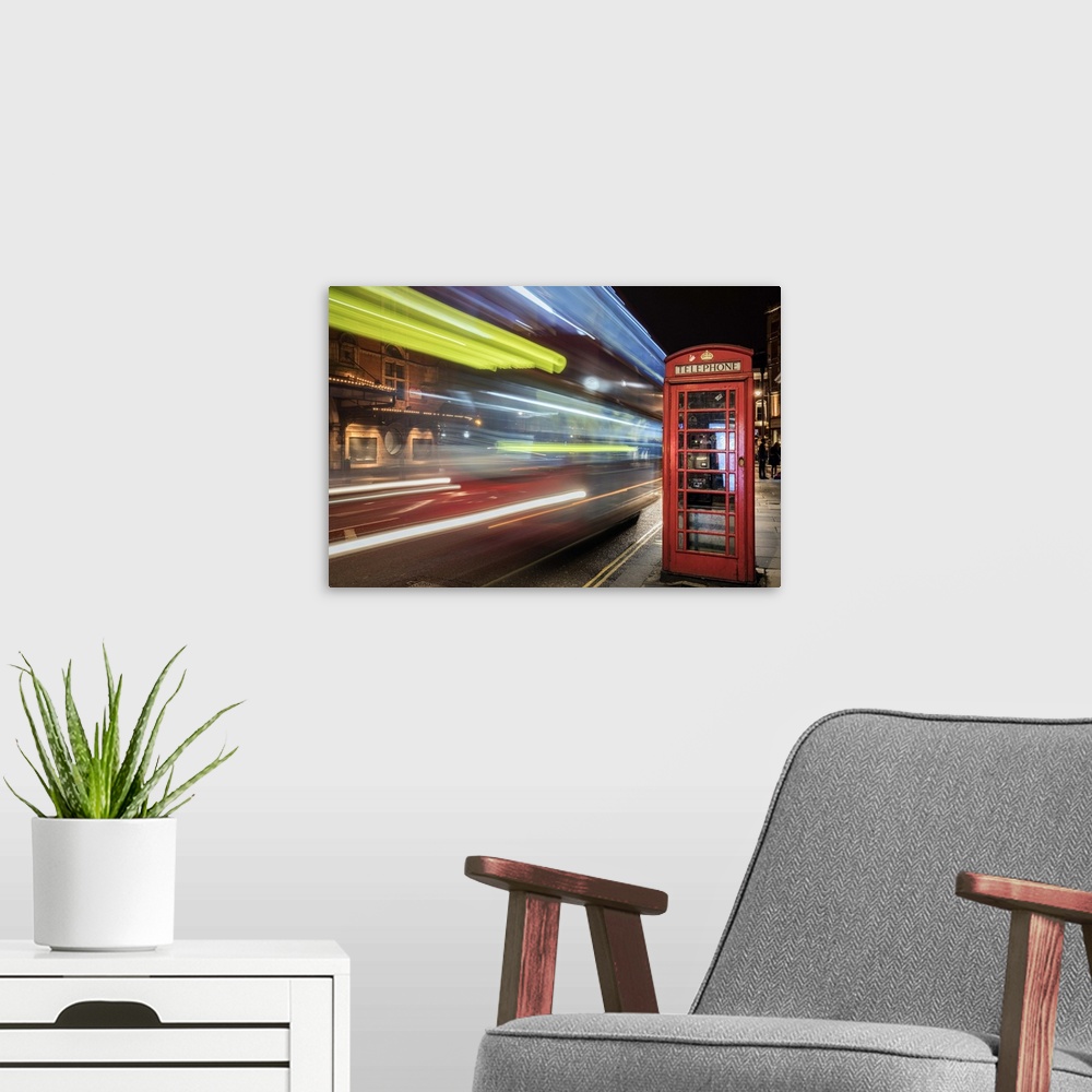 A modern room featuring An artistic photograph of telephone booth in London at the edge of a city street with bright neon...