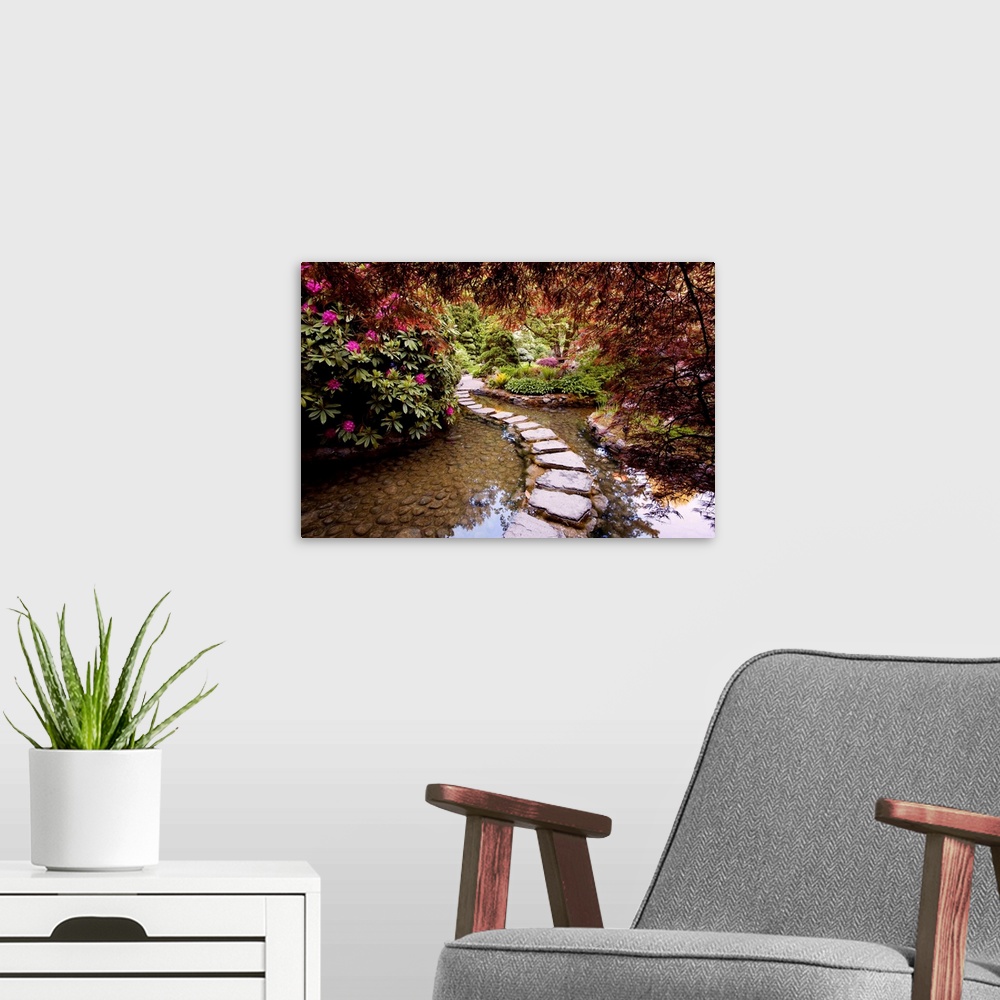 A modern room featuring Photograph of stepping stones over water through a garden in bloom.