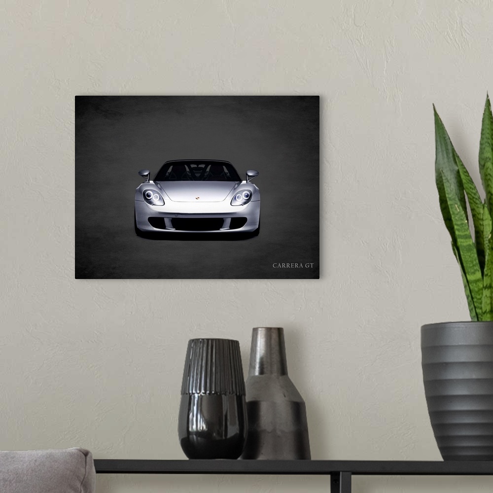 A modern room featuring Photograph of a silver Porsche Carrera GT printed on a black background with a dark vignette.