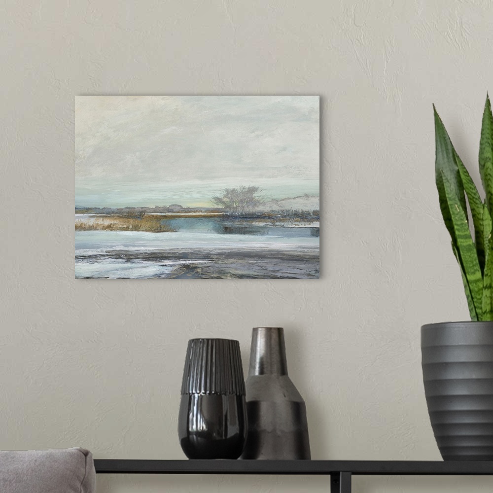 A modern room featuring Abstract landscape artwork of the edge where land meets water in subdued colors.
