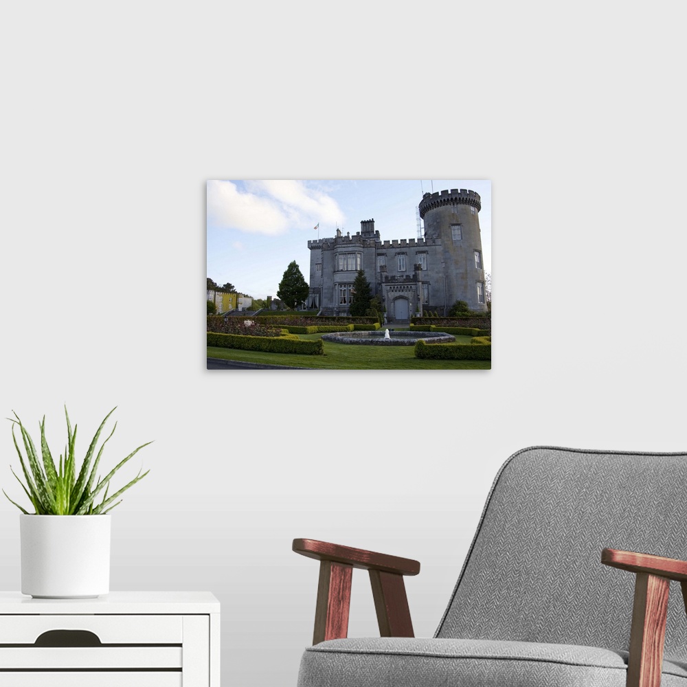 A modern room featuring Dromoland Castle Hotel in Newmaket-on-Fergus,Ireland, side view with a fountain,shrubs, lawn and ...