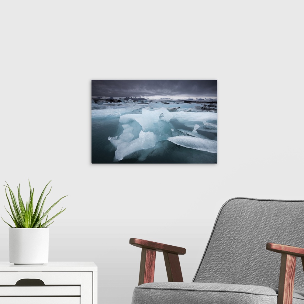 A modern room featuring Iceland, Skaftafell National Park, Storm clouds loom above icebergs from Vatnajokull Glacier in J...