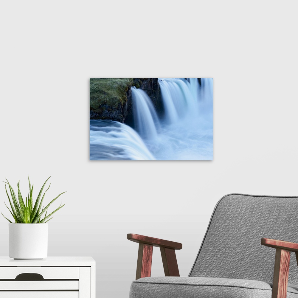 A modern room featuring Iceland, Godafoss Waterfall. Some of the small falls on the edges of the main fall look blue in t...
