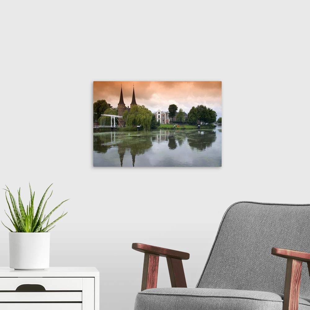 A modern room featuring The Eastern Gate and center along a canal in the city of Delft, Netherlands.