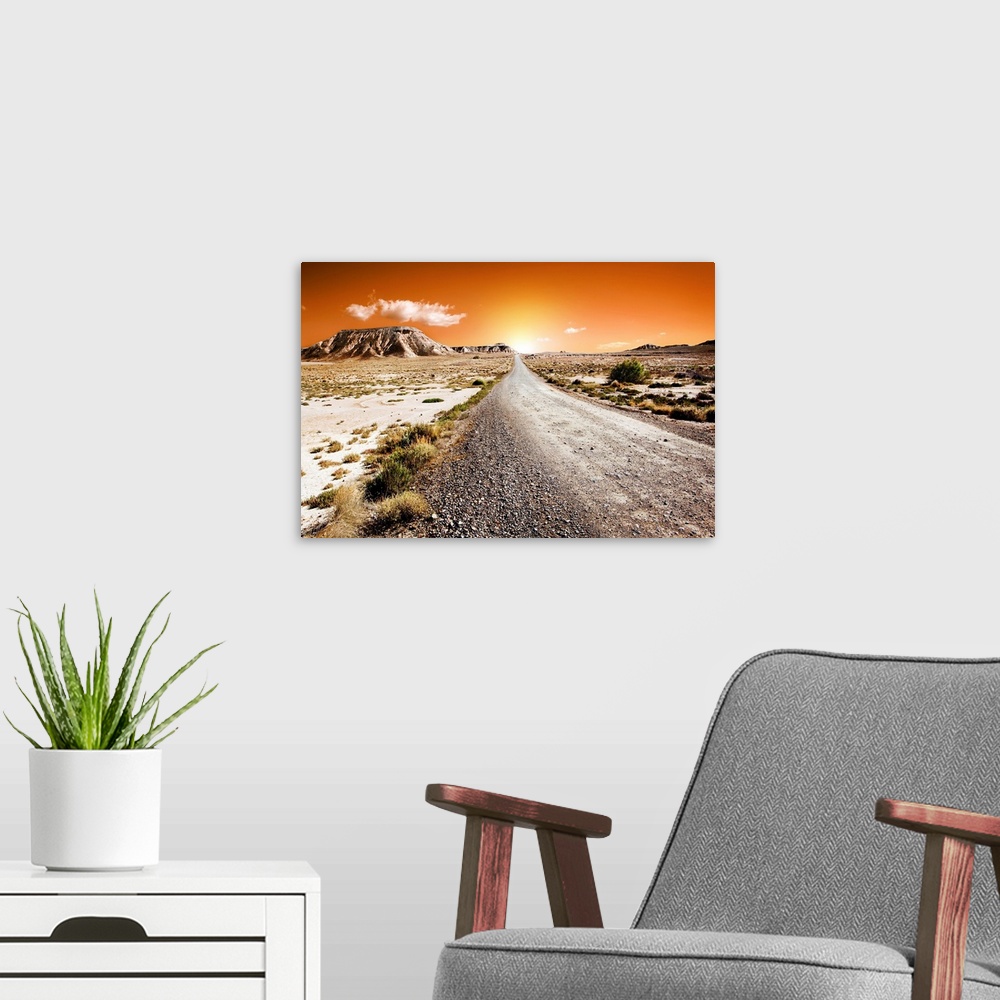 A modern room featuring Sunset desert landscape with road.
