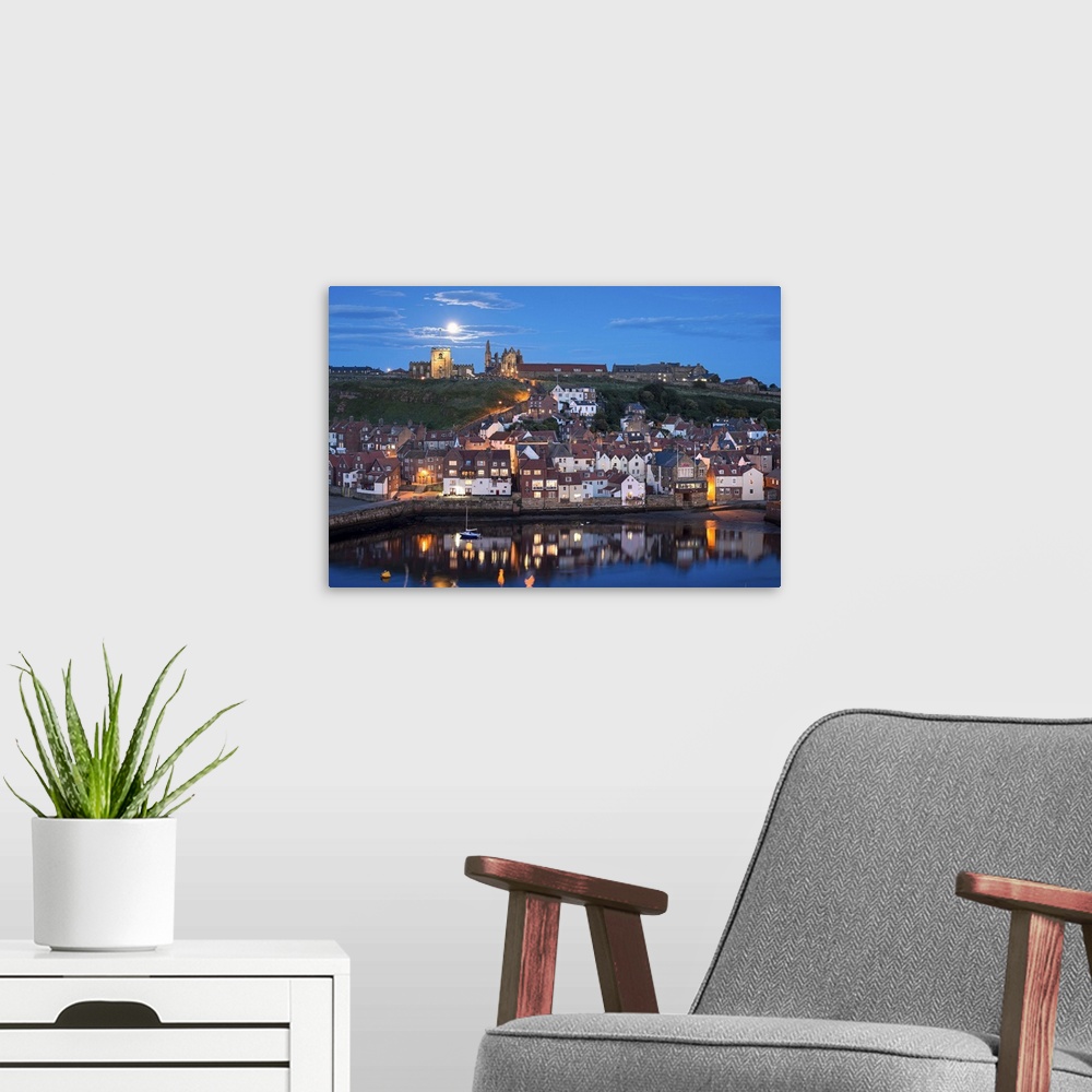 A modern room featuring England, North Yorkshire, Whitby, view across the town towards the abbey at night