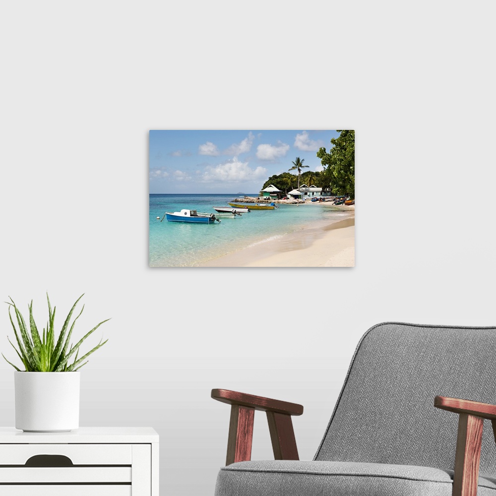 A modern room featuring Landscape photograph of blue Caribbean waters with anchored boats by the beach.