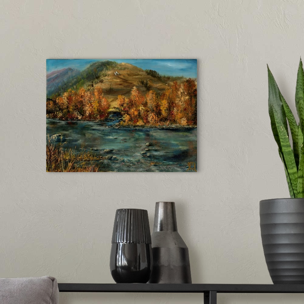 A modern room featuring Contemporary painting of a rocky river flowing in front of Autumn colored mountains.
