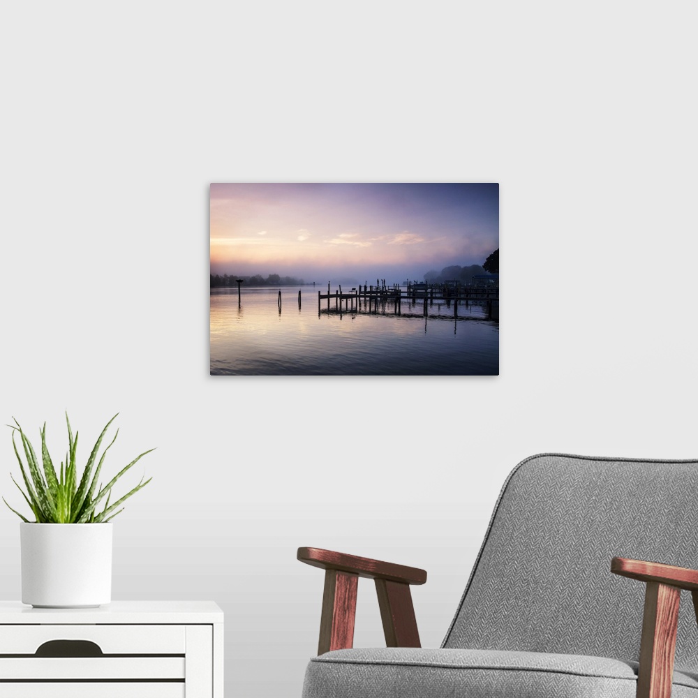A modern room featuring Silhouetted pier on a calm ocean in pastel sunrise light.