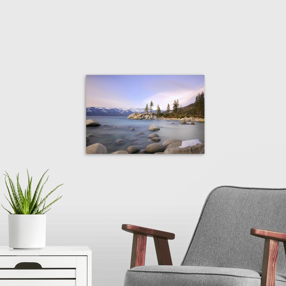 A modern room featuring Beautiful landscape with rocks and water against mountains in background.