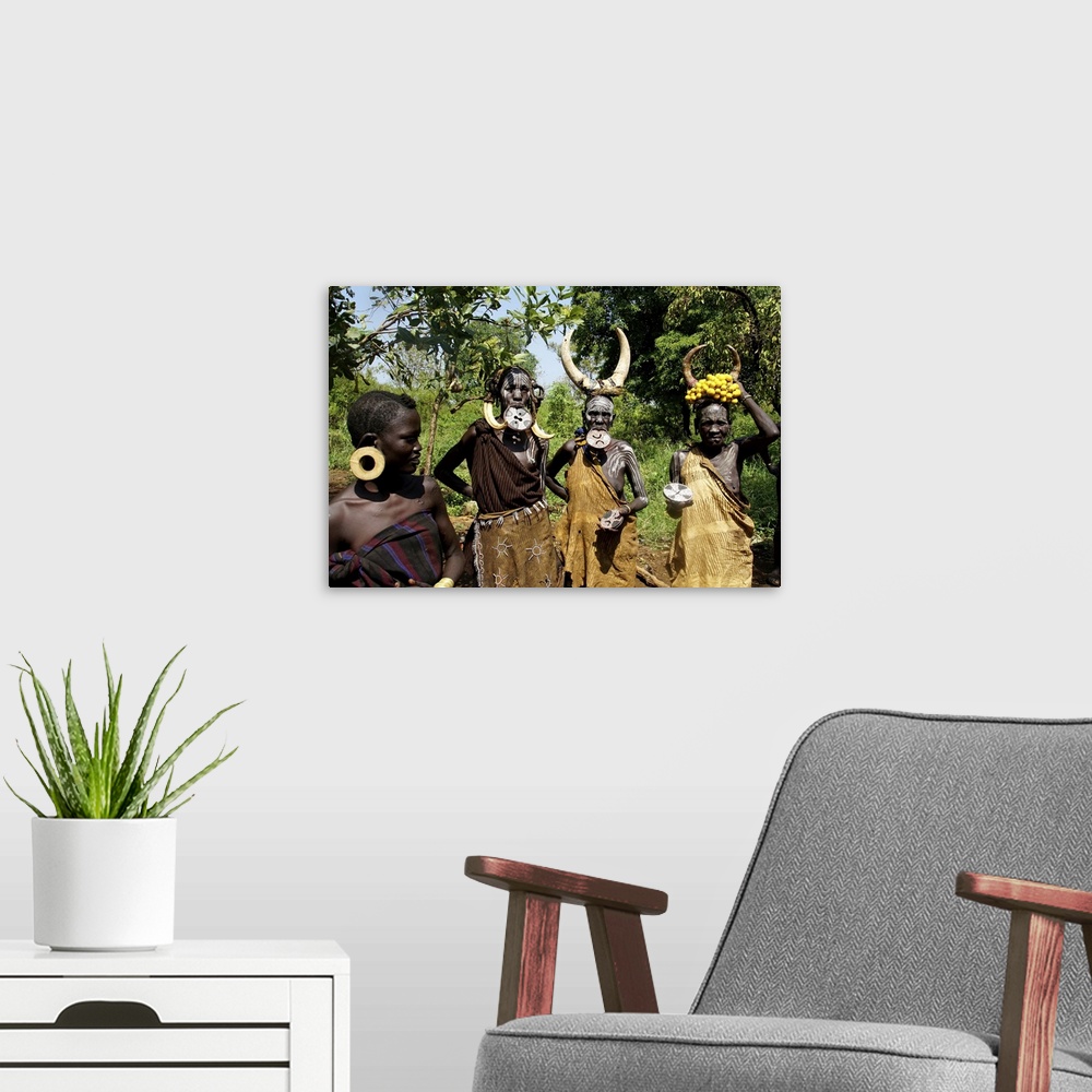 A modern room featuring Close up of four traditionally costumed Mursi women. Jinka, Ethiopia, Africa, February 21, 2020.