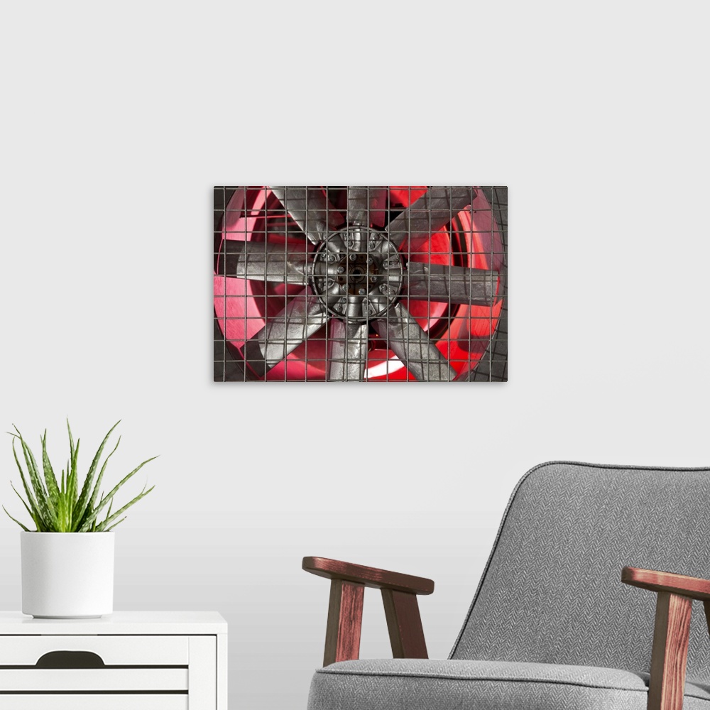 A modern room featuring Close up of industrial fan behind metal grate