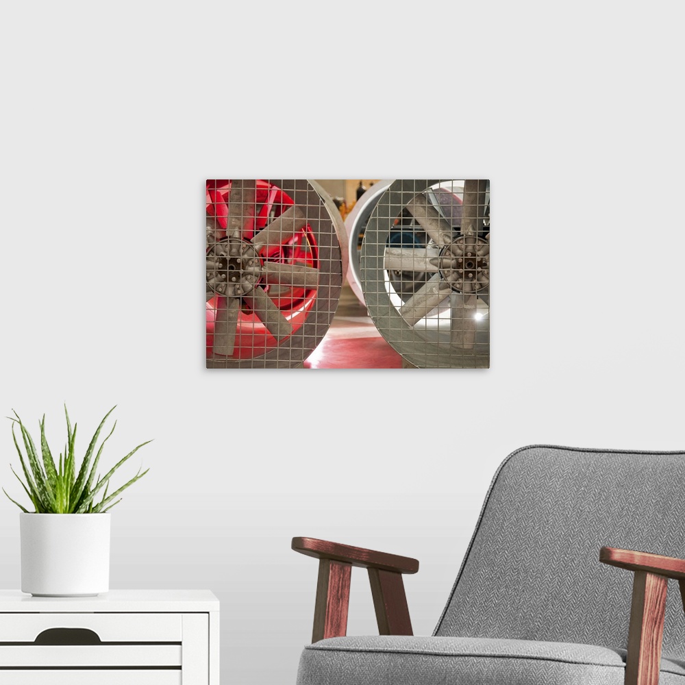 A modern room featuring Close up of industrial fans behind metal grate