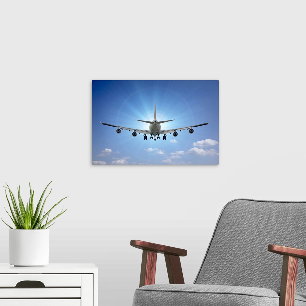 A modern room featuring Large airplane flies directly towards the sun on a clear blue day.