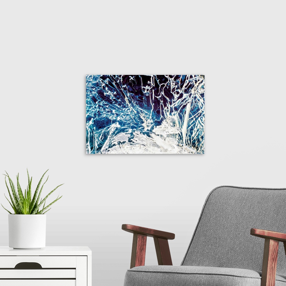 A modern room featuring Big, close up, landscape photograph of frozen water full of cracks and line in various directions.