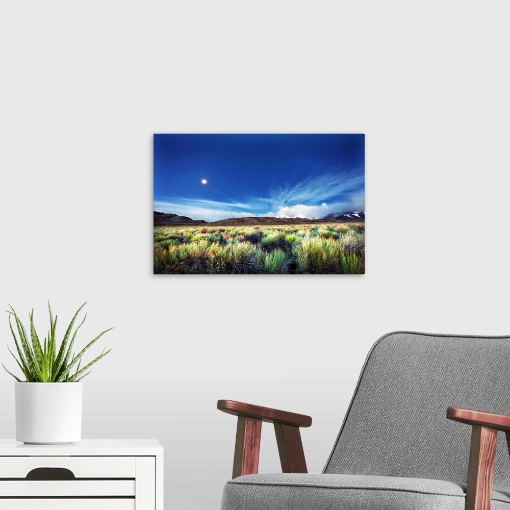 A modern room featuring Eastern Sierra mountain range and landscape glowing at sunrise with moon setting by Mono Lake res...