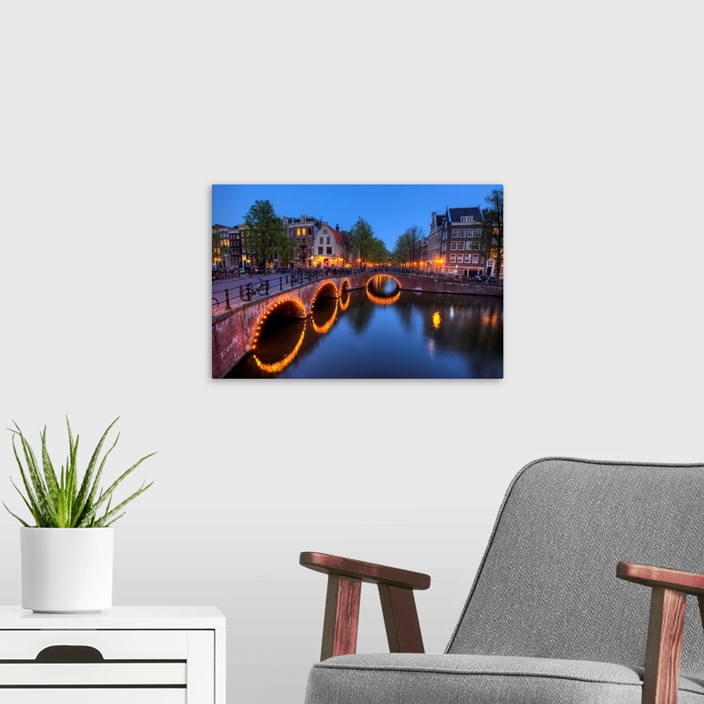 A modern room featuring Evening light old buildings and bridge along the many Canals of Amsterdam, Netherlands, at dusk t...