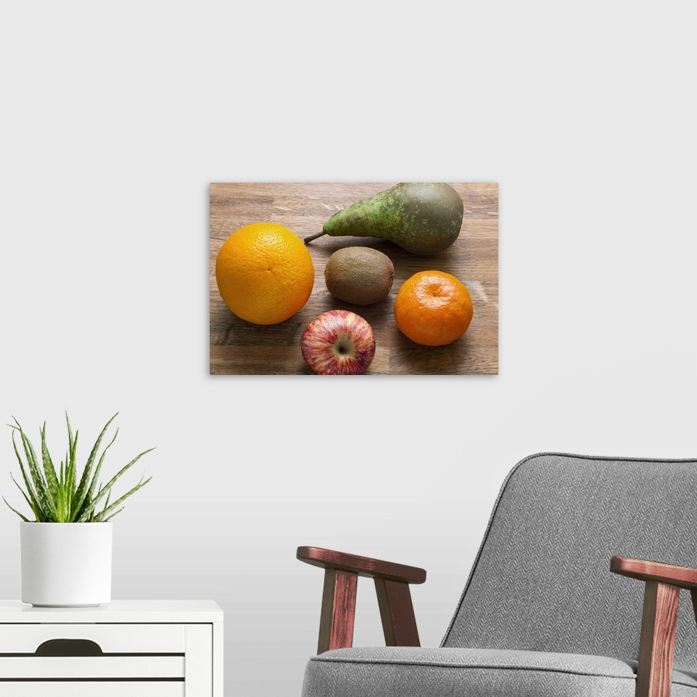 A modern room featuring Five mixed pieces of  fruit on a chopping board