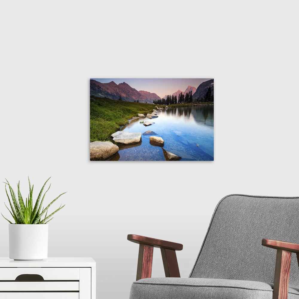 A modern room featuring Evening light over mountains of Teton Range reflected on still waters of Lake Solitude.
