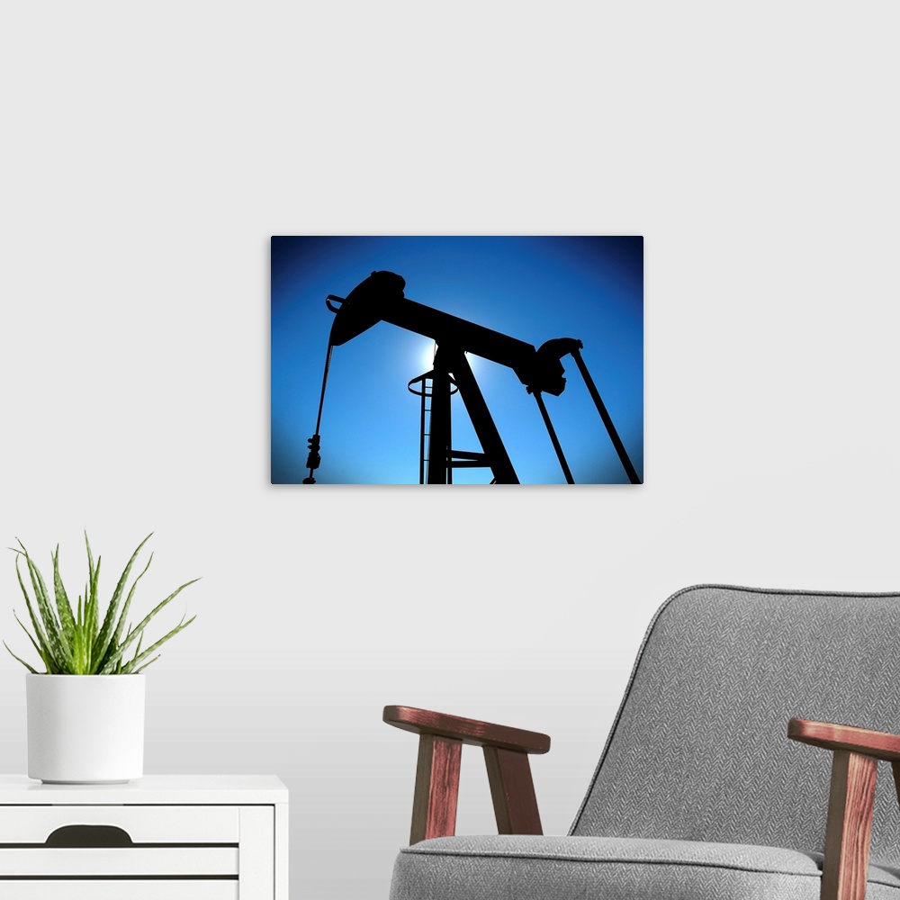 A modern room featuring Oil pump rig silhouetted on blue sky with heavy vignette.
