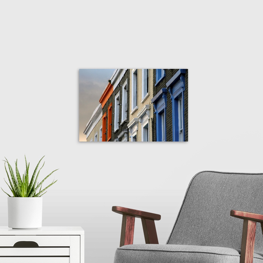A modern room featuring Painted window frames on series of terraced buildings on Camden High Street in London.