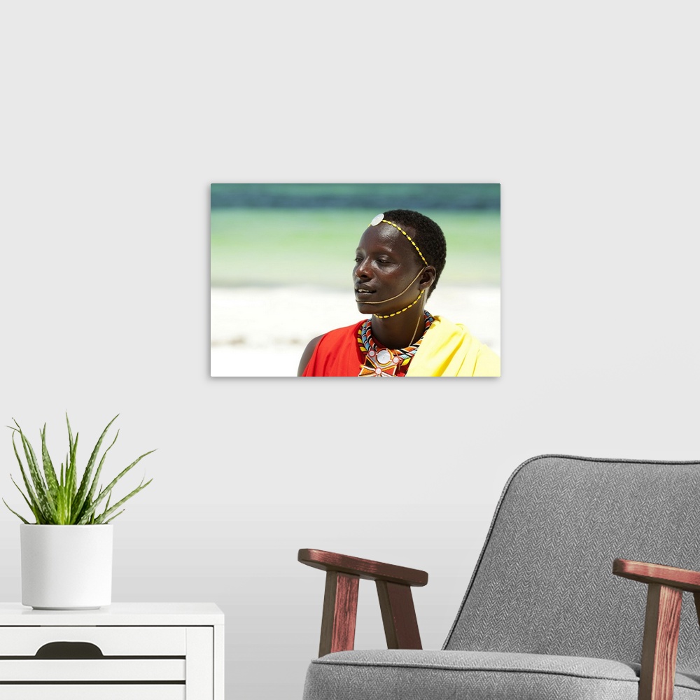 A modern room featuring Portrait of young tribal Masai warrior man on hot bright sunny African beach.