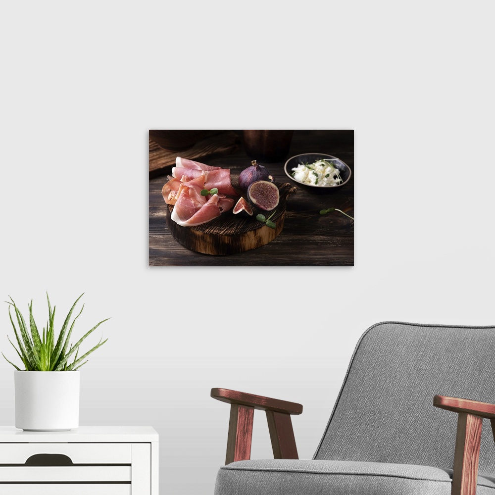 A modern room featuring Prosciutto slices with figs on a dark wooden background, appetizer from dry cured ham. Rustic sty...