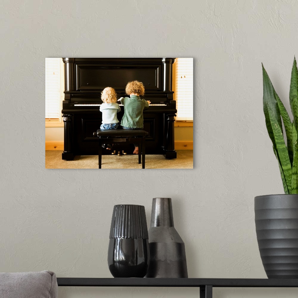 A modern room featuring Rear view of two children sitting at upright piano