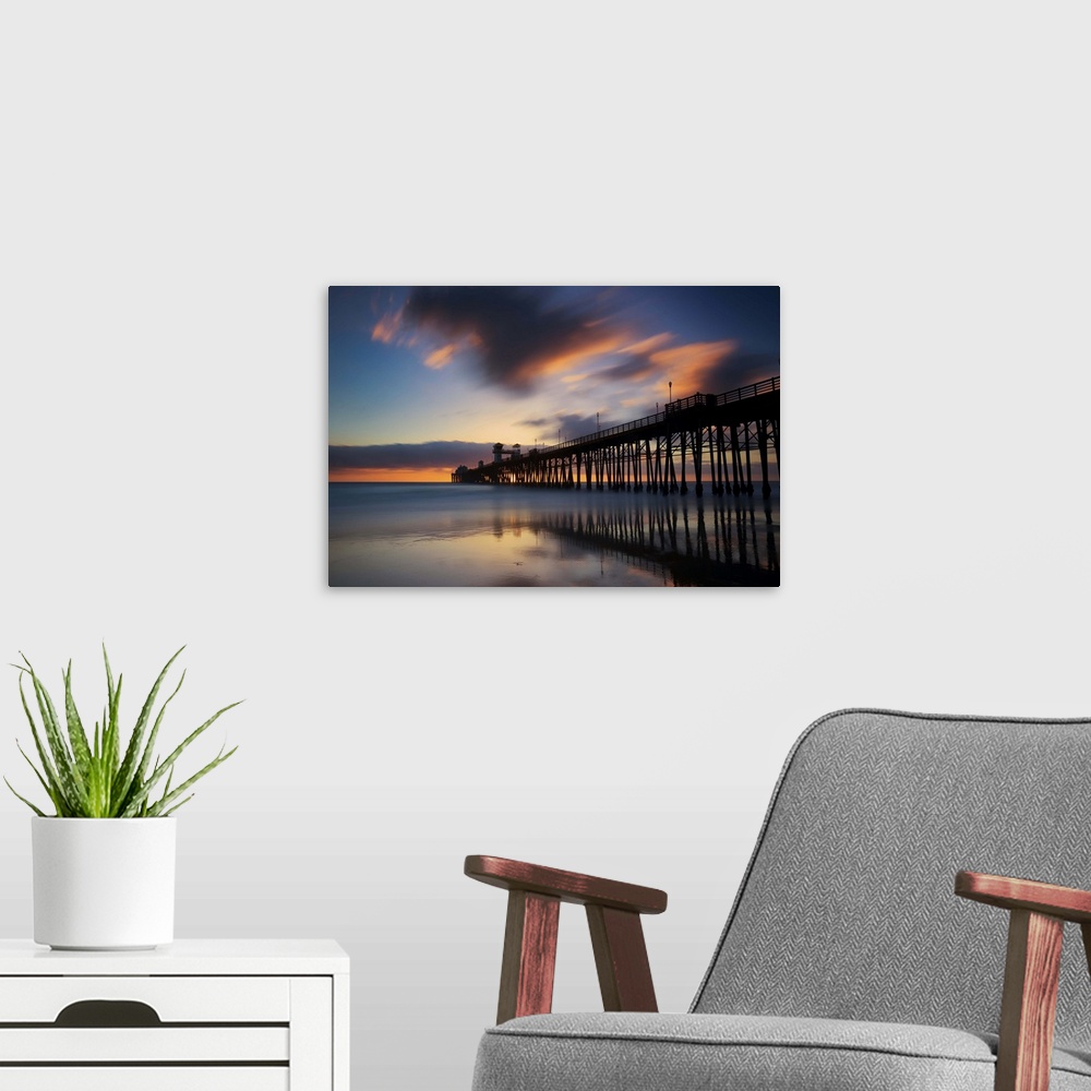 A modern room featuring Slow shutter speed capture of the Oceanside pier at sunset.